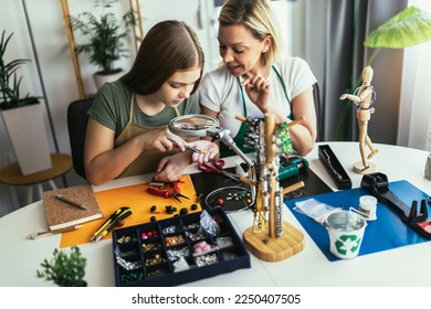 Mother and daughter accessories designers making handmade jewelry in studio workshop. Fashion, creativity and handmade concept.