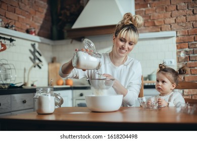 Mother and daughter baking cookies in their kitchen - Shutterstock ID 1618204498