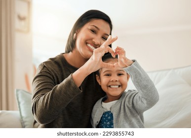 A mother and daughter bond is like no other. Shot of a young mother and son making a heart gesture with their hands at home. - Powered by Shutterstock