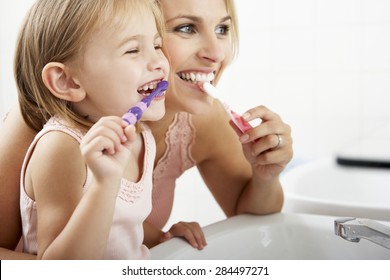 Mother And Daughter Brushing Teeth Together - Shutterstock ID 284497271