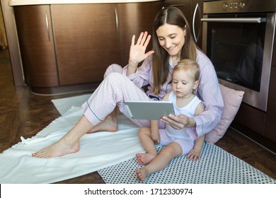 Mother And Daughter Call Online Relatives On A Tablet. Woman Waves Her Hand In The Ipad. Quarantine 2020