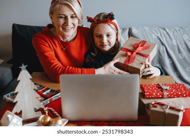 Mother and daughter celebrating Christmas virtually with loved ones. Virtual celebrations, online connections, holiday video calls, digital Christmas traditions, staying connected. - Powered by Shutterstock