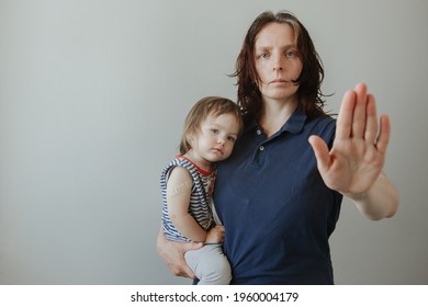 Mother And Daughter, A Child After Vaccination. The Woman Makes A Stop Gesture. Stop Viruses Concept