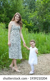 Mother And Daughter Child Walking On Meadow Way Copyspace Photography. Happiness Smiling Woman Mom Parent And Little Girl Kid Walk On Agricultural Flowers Field Road Togetherness. Funny Family Time