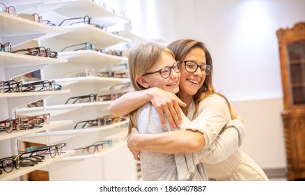 Mother and daughter choosing and trying different glasses at the optometrist. - Shutterstock ID 1860407887