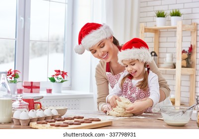 Mother And Daughter Cooking Christmas Biscuits