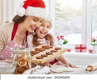 Mother And Daughter Cooking Christmas Biscuits