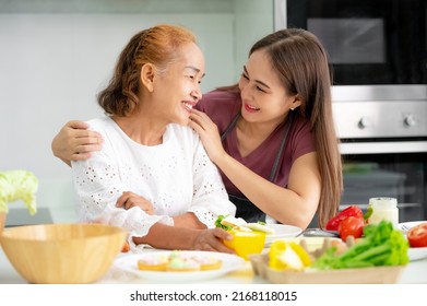 mother and daughter cooking in the kitchen, mother and daughter hugging to love on mother's day, Asian family - Shutterstock ID 2168118015