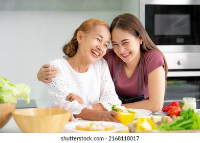 mother and daughter cooking in the kitchen, mother and daughter hugging to love on mother's day, Asian family - Shutterstock ID 2168118017