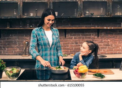 Mother And Daughter Cooking On Kitchen