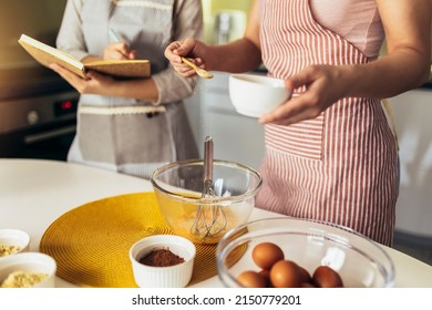 Mother And Daughter Cooking Together In The Kitchen, Close Up.