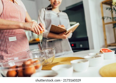 Mother And Daughter Cooking Together In The Kitchen, Close Up.