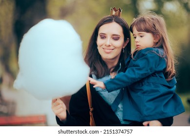 
Mother and Daughter Craving Sugary Cotton Candy Dessert. Adorable girl curious to taste a funfair sugary treat for the first time
