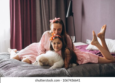 Mother and daughter with dog in bed - Shutterstock ID 1067436641