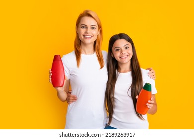 Mother And Daughter Doing Morning Hair Care. Smiling Mom And Kid In Show Clean Mockup Shampoo, Conditioner Or Face Wash Bottles. Children And Adults Dermatology Products.