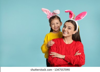 Mother And Daughter In Easter Bunny Ears Headbands On Color Background, Space For Text