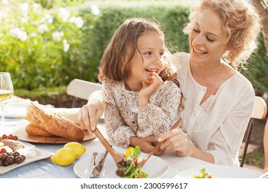 Mother and daughter eating in garden - Powered by Shutterstock