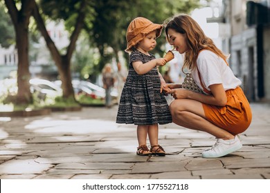 Mother with daughter eating icecream at the street - Powered by Shutterstock