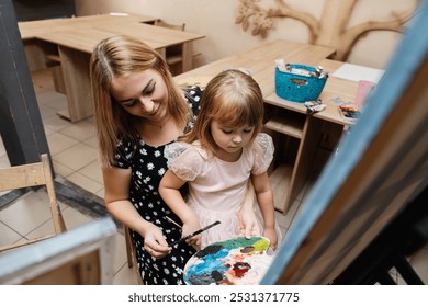 Mother and daughter enjoy a creative painting session in an art studio - Powered by Shutterstock