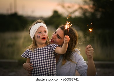 Mother And Daughter Enjoy Fourth Of July Sparklers Together