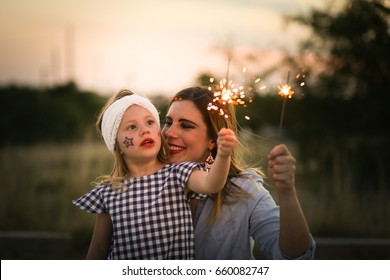 Mother And Daughter Enjoy Fourth Of July Sparklers Together