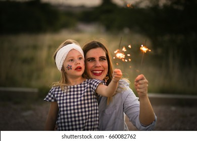 Mother And Daughter Enjoy Fourth Of July Sparklers Together