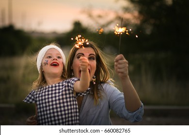 Mother And Daughter Enjoy Fourth Of July Sparklers Together