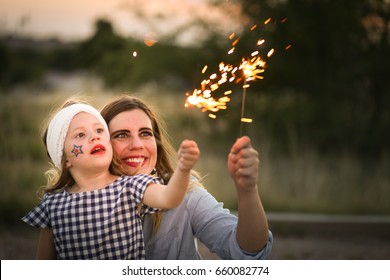 Mother And Daughter Enjoy Fourth Of July Sparklers Together