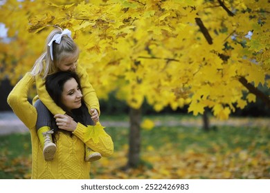 Mother and Daughter Enjoying Autumn Day Among Yellow Maple Leaves in the Park - Powered by Shutterstock