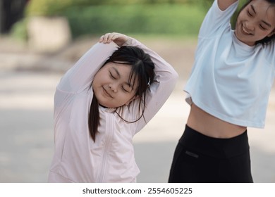 Mother and Daughter Enjoying Outdoor Exercise Together in a Park on a Sunny Day, Promoting Healthy Lifestyle and Family Bonding Through Physical Activity - Powered by Shutterstock