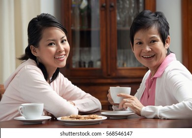 Mother and daughter enjoying tea together - Shutterstock ID 568546147