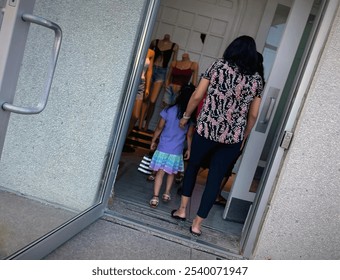 Mother and daughter at the entrance of the shopping mall, back view - Powered by Shutterstock