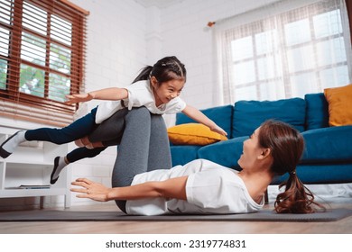 Mother and daughter exercising together happily at home. for flexibility build muscle strength, Sport workout training family together concept. - Powered by Shutterstock