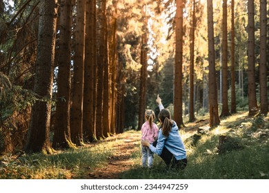 Mother and daughter exploring forest, enjoying wildlife nature looking up at the trees  - Powered by Shutterstock