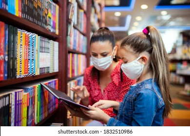 Mother And Daughter With Face Mask Shopping In Bookshop, Coronavirus Concept.