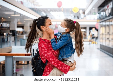 Mother and daughter with face mask standing indoors in shopping center, coronavirus concept. - Powered by Shutterstock