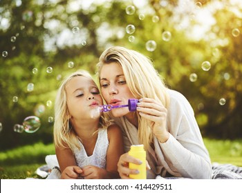 Mother and daughter family time, blowing bubbles