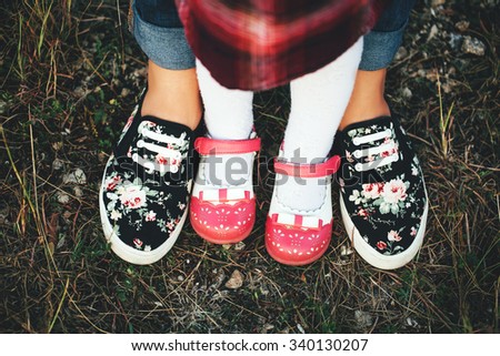 Mother and daughter feets in boots in the nature