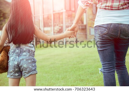 A Mother and daughter in front of the house