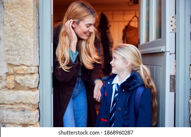 Mother And Daughter Getting Ready To Leave Home For School In The Morning Standing By Door