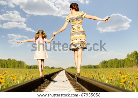 Mother with the daughter go on rails,  back to a camera, on nature, in the summer