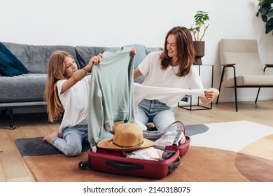 Mother and daughter going on trip pack suitcase - Powered by Shutterstock