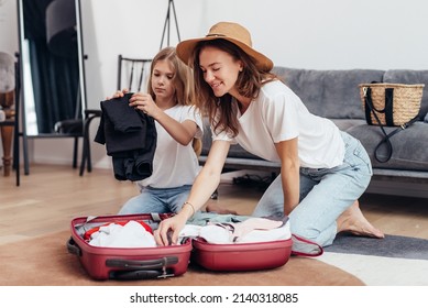 Mother and daughter going on trip pack suitcase