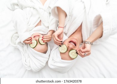 Mother And Daughter Had A Day Of Spa Doing Face Mask Applying Pieces Of Cucumber To Their Eyes. Beauty Salon Concept, Wellness Spa.