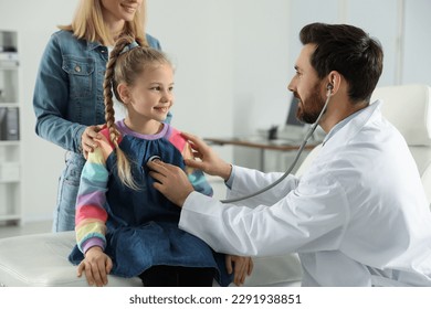 Mother and daughter having appointment with doctor. Pediatrician examining patient with stethoscope in clinic - Powered by Shutterstock