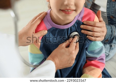 Mother and daughter having appointment with doctor. Pediatrician examining patient with stethoscope, closeup