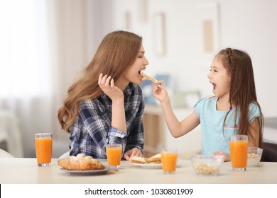 Mother with daughter having breakfast in kitchen - Powered by Shutterstock