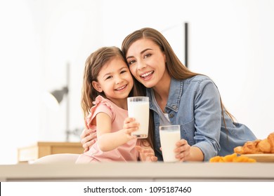 Mother And Daughter Having Breakfast With Milk At Table