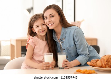 Mother And Daughter Having Breakfast With Milk At Table