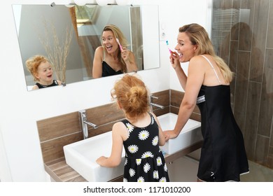 Mother and Daughter having fun during brushing teeth in a modern Bathroom
